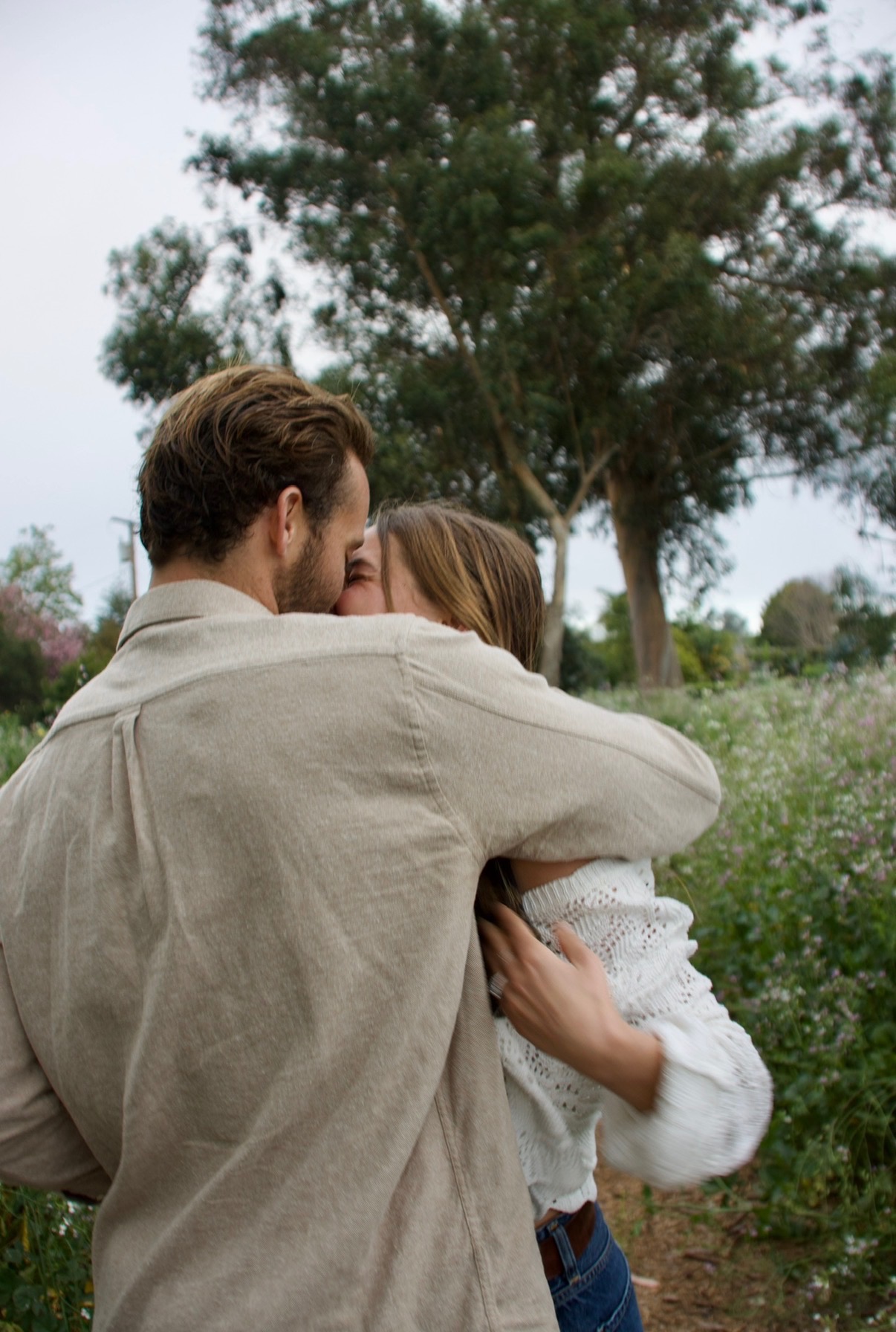 Claire and Willy kissing in a wildflower field